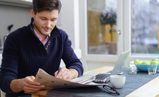 Man circling ads in newspaper